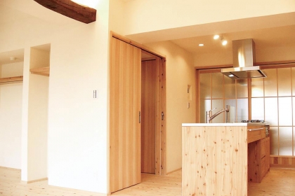 回遊式の造作キッチン。ステンレスの天板にベースから家具調の框扉まで、北海道産唐松の無垢材を使用している。
